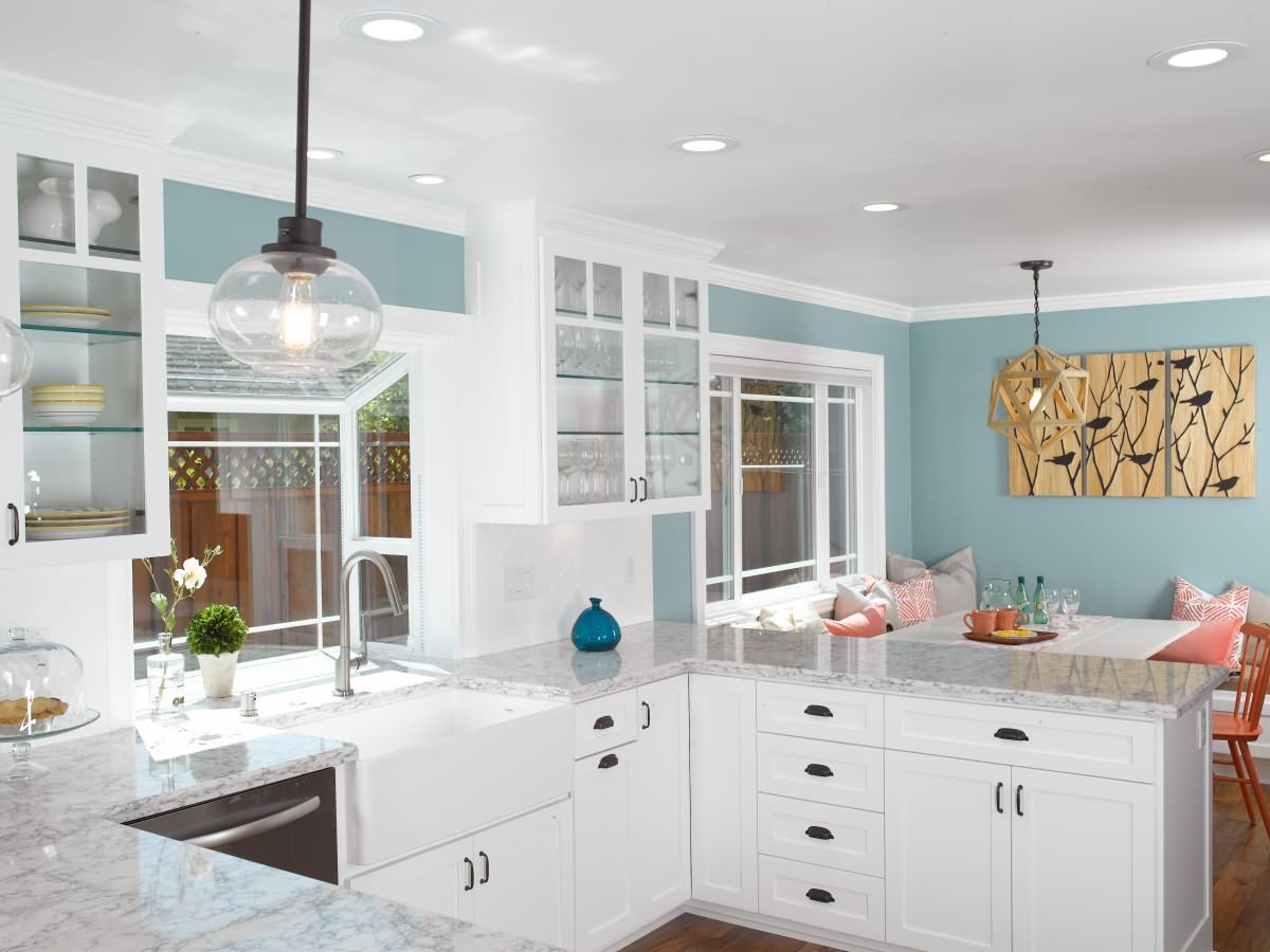 This kitchen features white shaker cabinets with engineered quartz counter top.  Customer selected a new garden window, recessed lights, crown moldings, and acacia flooring to brighten the kitchen.