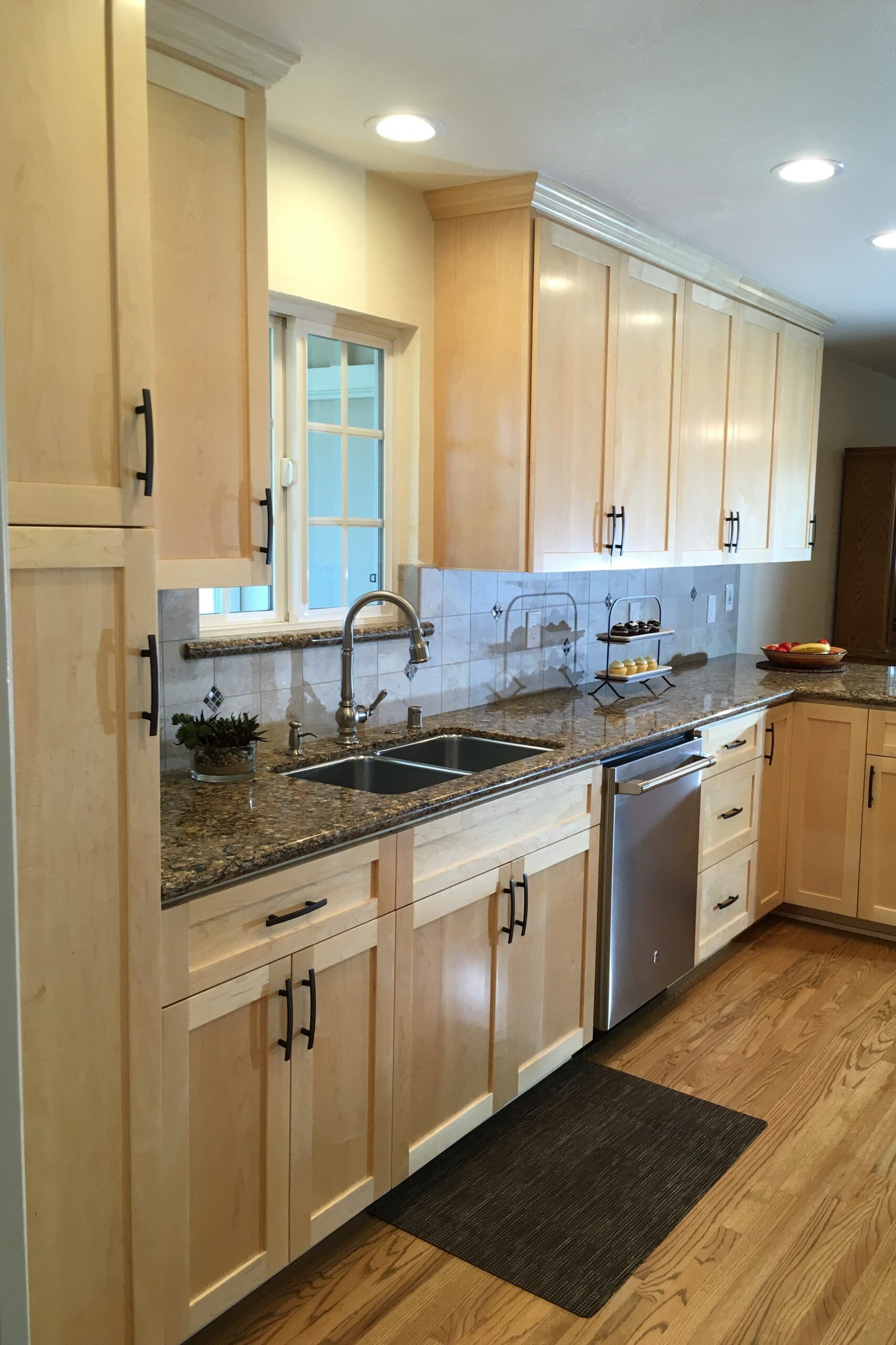 Natural maple cabinets, tile backsplash, and oak floors complete this light San Jose kitchen.
