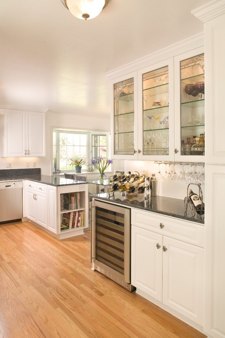 white cabinets, granite counter tops, wine cooler, wood floors, window, glass cabinet doors